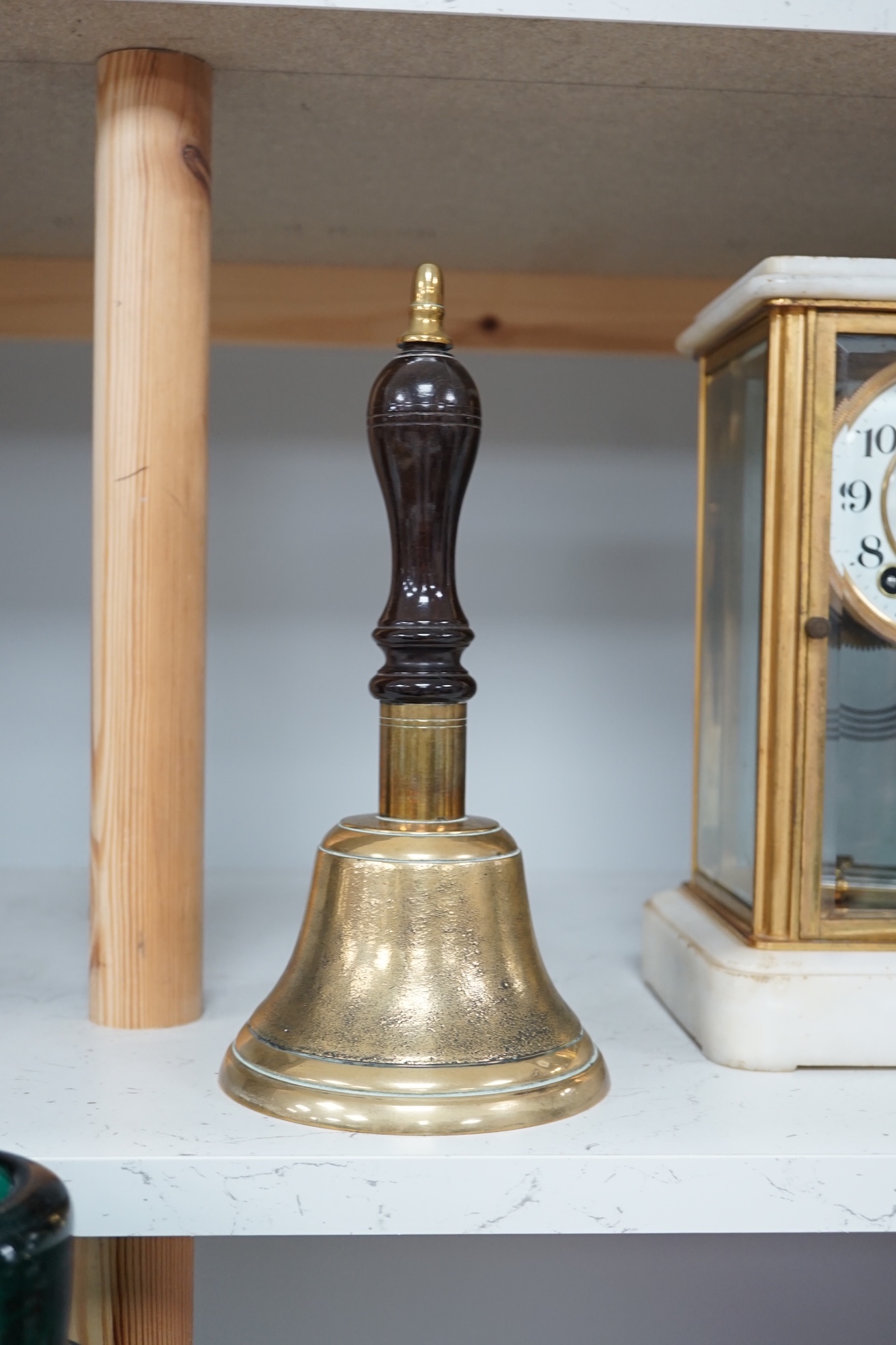 A late 19th/early 20th century brass school bell, with a turned mahogany handle, bell diameter 12.5cm, height 26cm. Condition - fair to good.